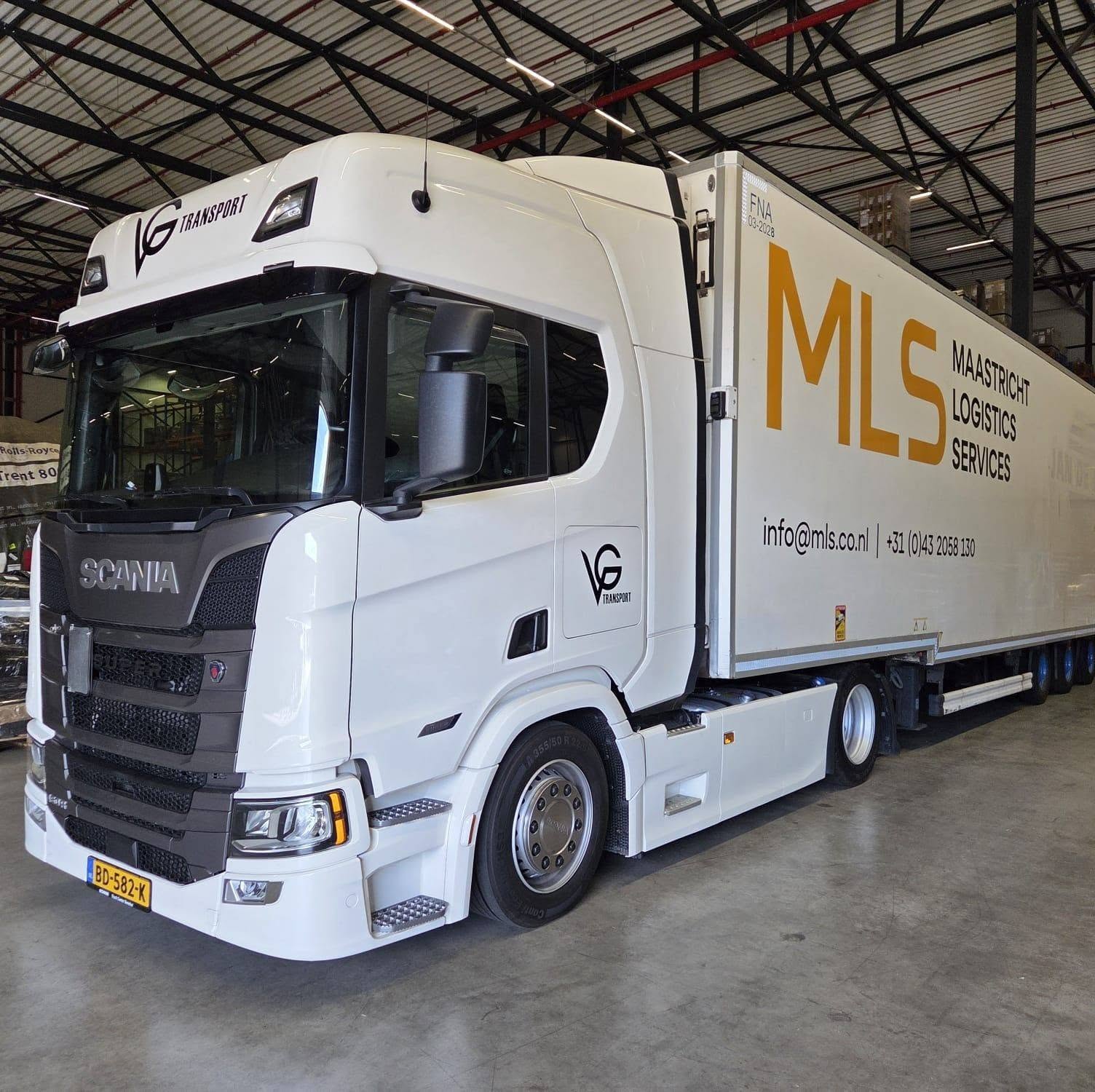 Witte VG-trekker met oplegger in een loods
